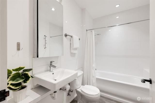 full bathroom featuring tile walls, sink, shower / bath combo, and toilet