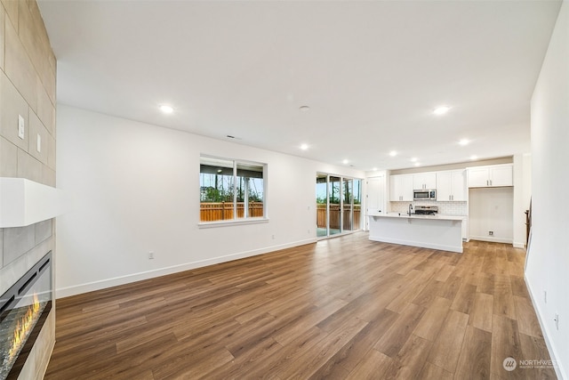 unfurnished living room with a fireplace and light wood-type flooring