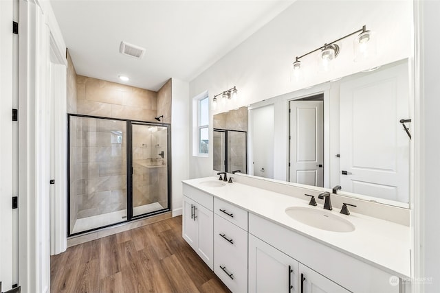 bathroom featuring vanity, hardwood / wood-style floors, and a shower with shower door