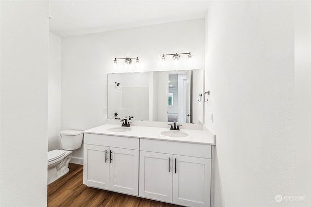 bathroom featuring hardwood / wood-style flooring, vanity, toilet, and a shower