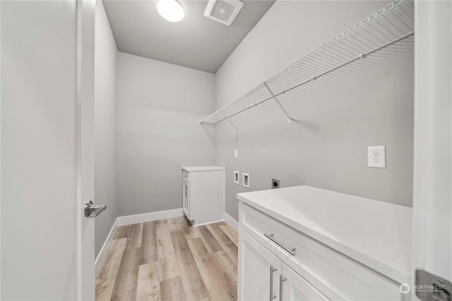 clothes washing area with cabinets, hookup for an electric dryer, washer hookup, and light hardwood / wood-style flooring