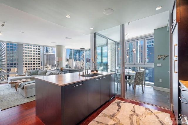 kitchen with a wall of windows, dark hardwood / wood-style flooring, kitchen peninsula, and sink