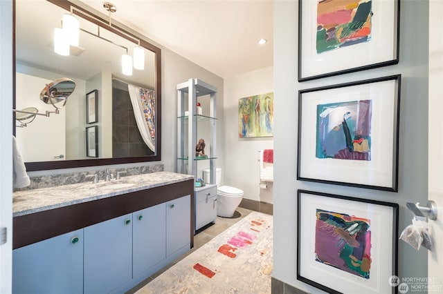 bathroom with vanity, tile patterned flooring, and toilet