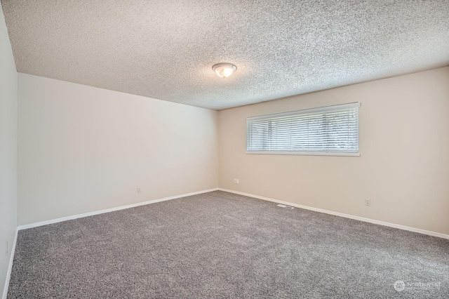 carpeted spare room with a textured ceiling