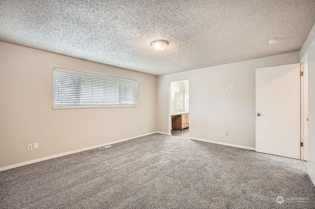 unfurnished room featuring a textured ceiling and carpet