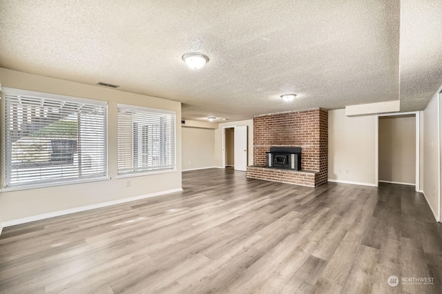 unfurnished living room with hardwood / wood-style flooring and a textured ceiling