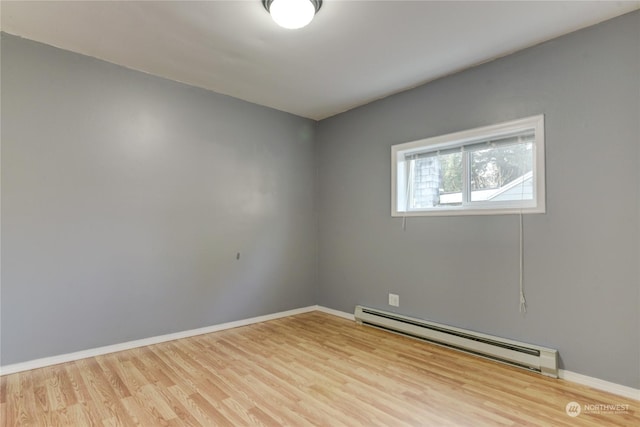 spare room with hardwood / wood-style flooring and a baseboard radiator