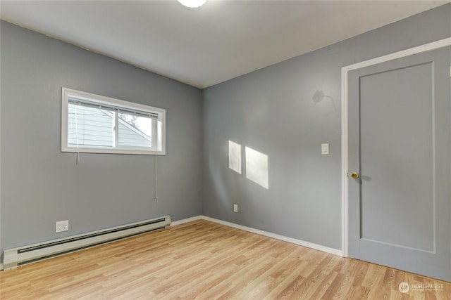 spare room with light wood-type flooring and baseboard heating