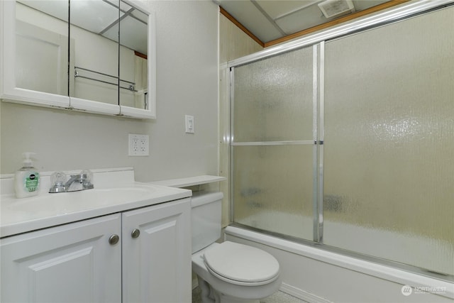 full bathroom with bath / shower combo with glass door, vanity, and toilet