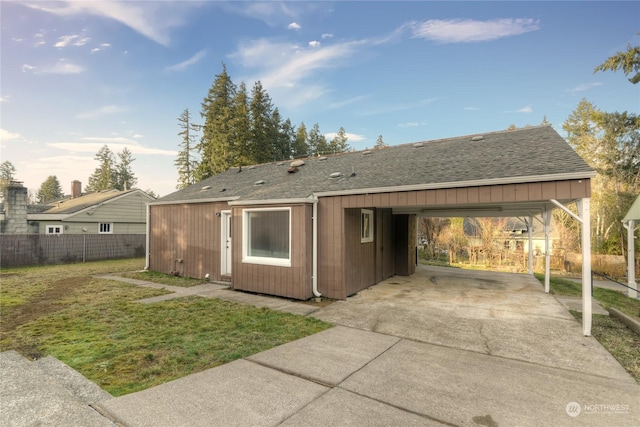 back of house featuring a carport and a yard