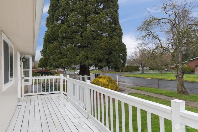 wooden deck featuring a lawn