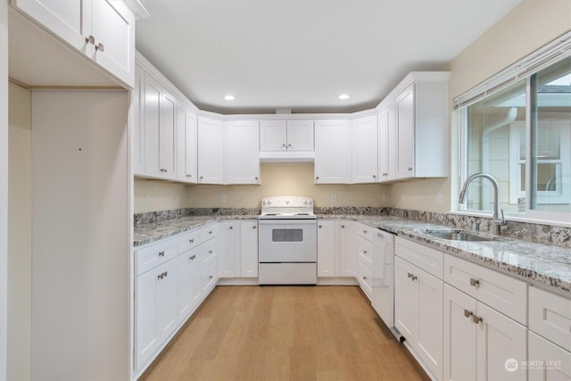 kitchen with white cabinetry, white appliances, sink, and light stone counters