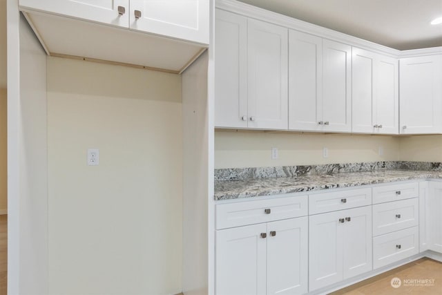 kitchen with light stone countertops and white cabinets