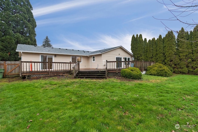 rear view of property with a yard and a deck