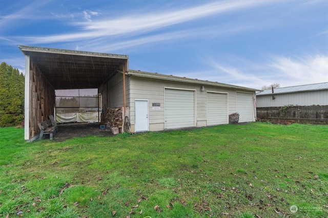 view of outbuilding with a carport, a yard, and a garage