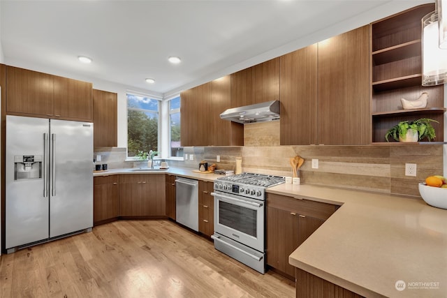 kitchen with sink, light hardwood / wood-style flooring, appliances with stainless steel finishes, tasteful backsplash, and extractor fan