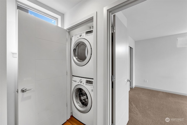 clothes washing area featuring stacked washer and dryer and light colored carpet