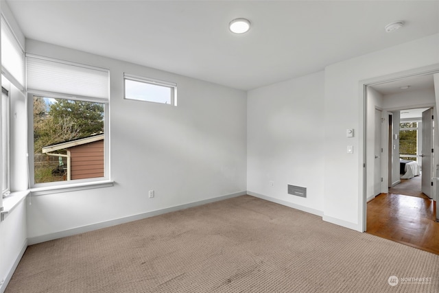 unfurnished room featuring light carpet