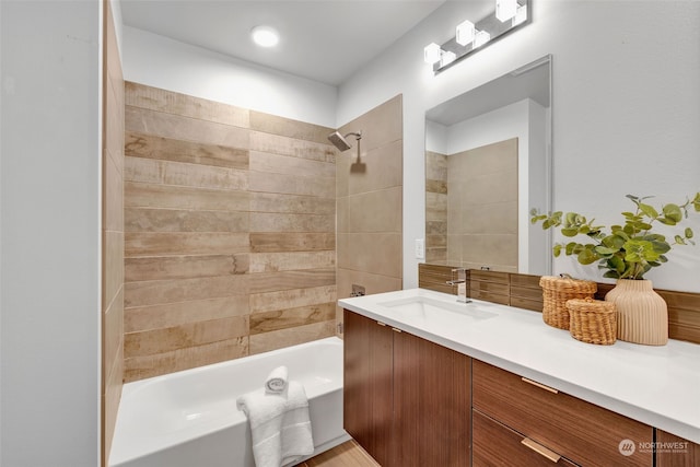 bathroom with tiled shower / bath combo and vanity