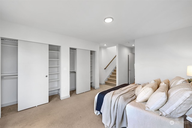 carpeted bedroom featuring two closets