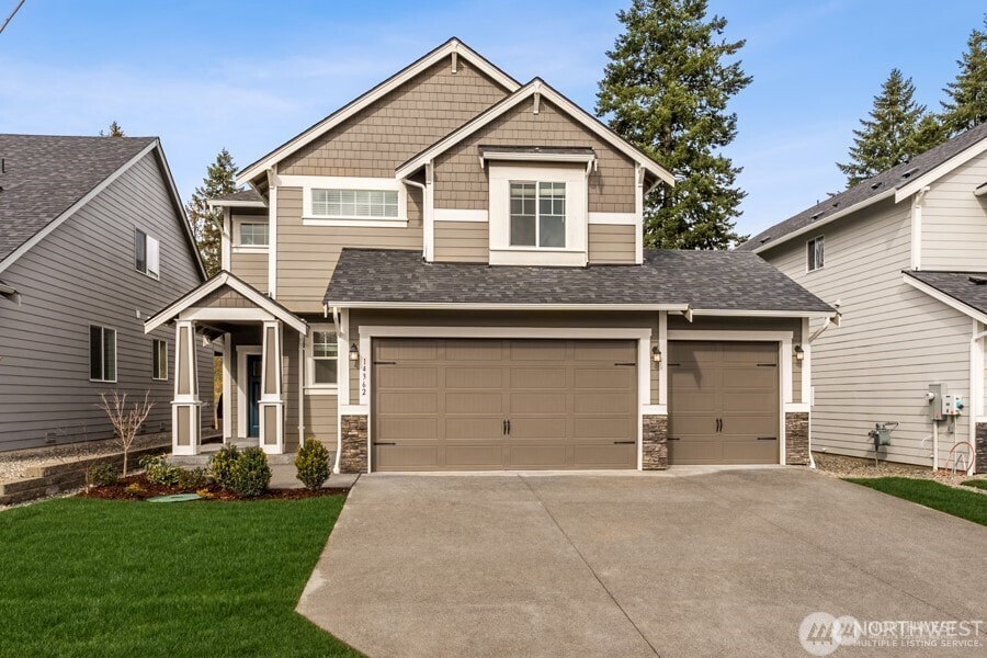 9981 Merrick St SE Unit 371, Yelm, WA 98597 - craftsman-style home featuring roof with shingles, concrete driveway, a front lawn, and stone siding