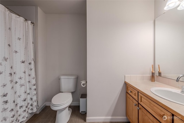 bathroom with walk in shower, vanity, and toilet