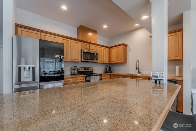 kitchen with appliances with stainless steel finishes, a breakfast bar, and sink