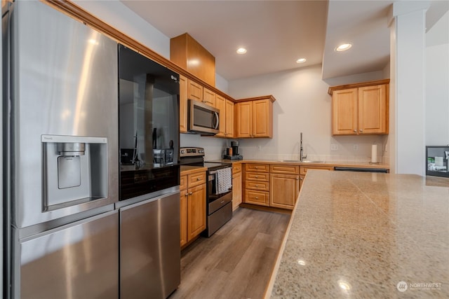 kitchen featuring decorative columns, wood-type flooring, appliances with stainless steel finishes, and sink