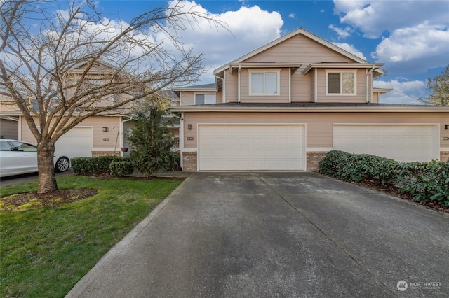 view of property featuring a garage and a front lawn