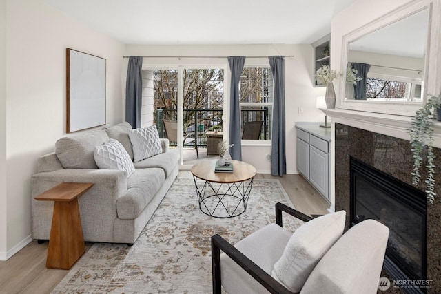 living room with light hardwood / wood-style flooring and a tile fireplace