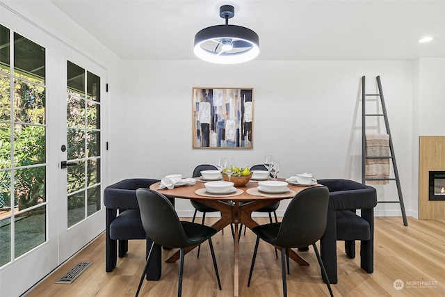 dining space featuring french doors and light wood-type flooring