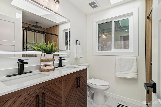 bathroom featuring vanity, toilet, and a skylight