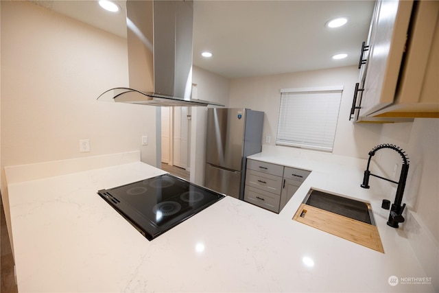 kitchen featuring island range hood, stainless steel refrigerator, sink, gray cabinetry, and black electric cooktop