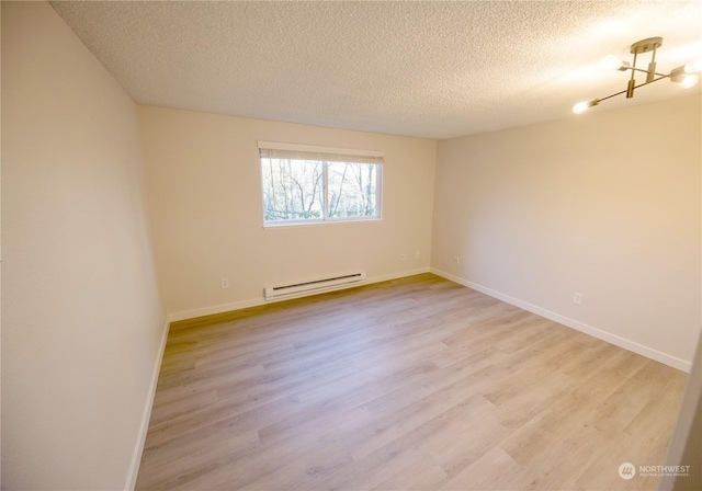 unfurnished room with light wood-type flooring, a textured ceiling, and baseboard heating