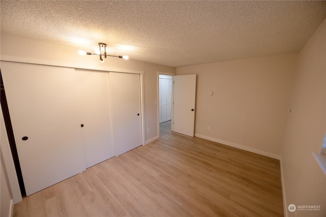 unfurnished bedroom with hardwood / wood-style floors, a textured ceiling, and a closet