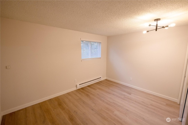 unfurnished room with baseboard heating, light hardwood / wood-style floors, a textured ceiling, and a notable chandelier