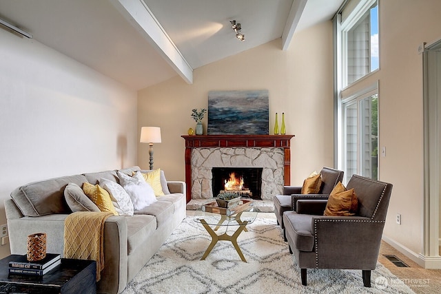 living area featuring vaulted ceiling with beams, baseboards, visible vents, and a stone fireplace