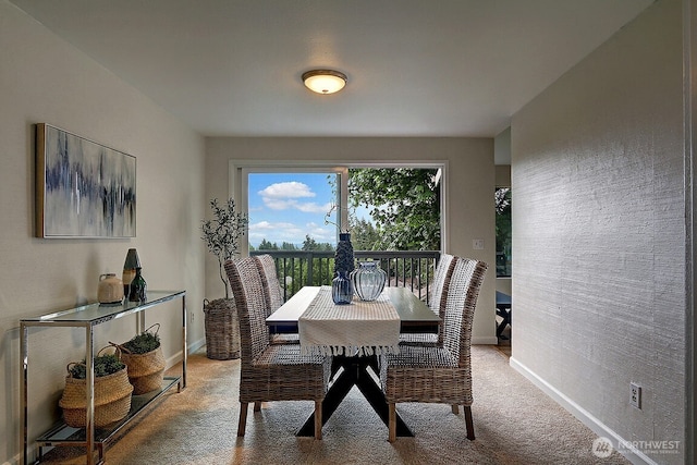 dining room with light colored carpet and baseboards