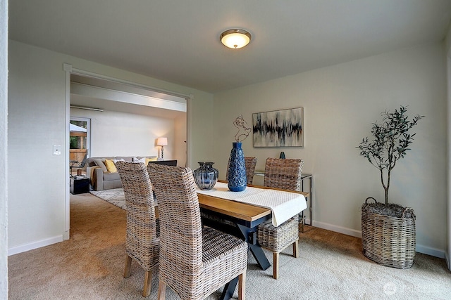 dining space with light carpet and baseboards