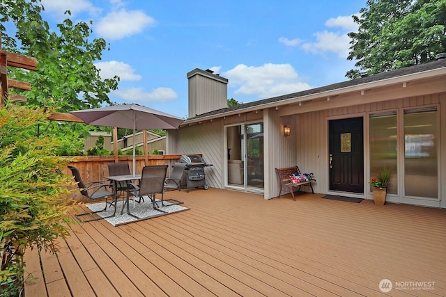 wooden terrace with grilling area and outdoor dining space