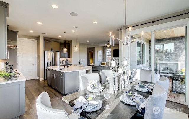 dining area with ceiling fan, sink, and dark hardwood / wood-style flooring