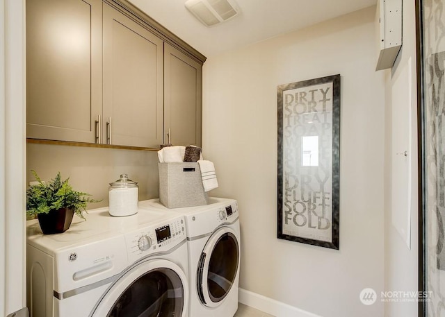 clothes washing area with cabinets and washing machine and dryer