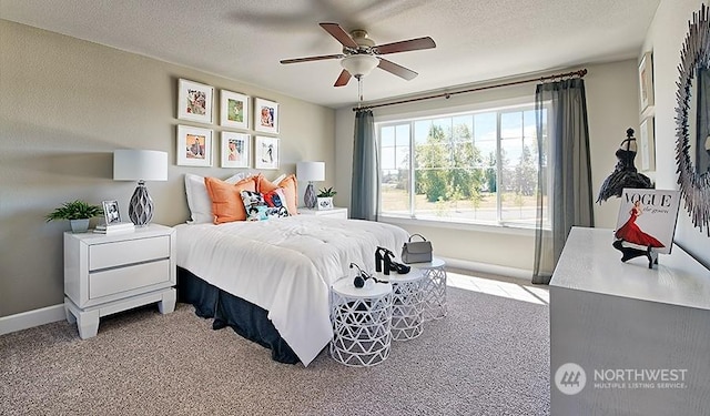 carpeted bedroom featuring ceiling fan and a textured ceiling