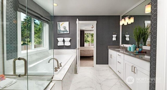 bathroom featuring tiled tub and vanity