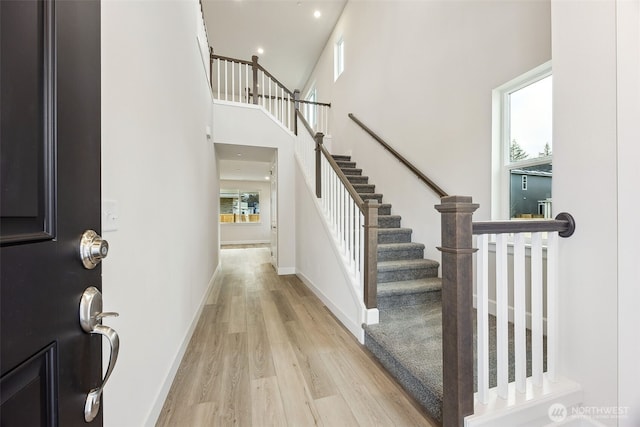 foyer with light hardwood / wood-style floors and a high ceiling