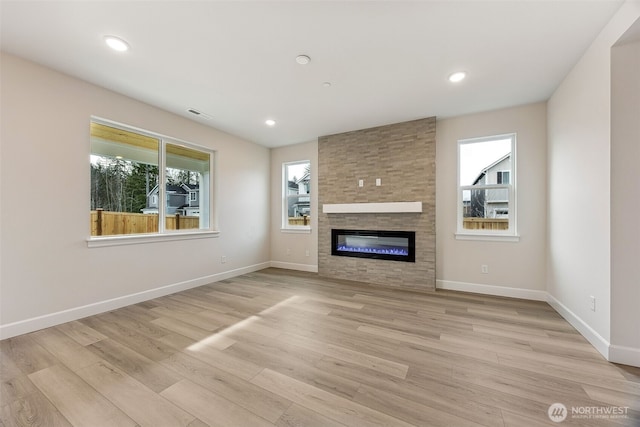 unfurnished living room featuring a fireplace and light hardwood / wood-style flooring