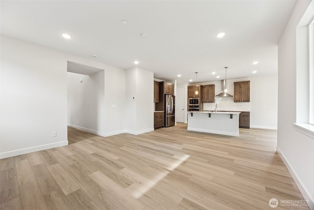 unfurnished living room featuring sink and light hardwood / wood-style flooring