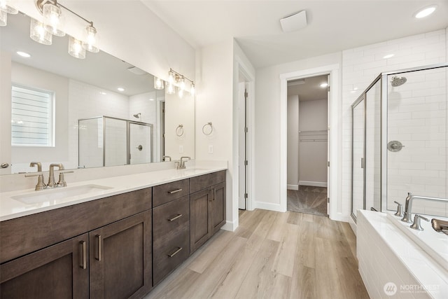 bathroom with shower with separate bathtub, hardwood / wood-style floors, and vanity