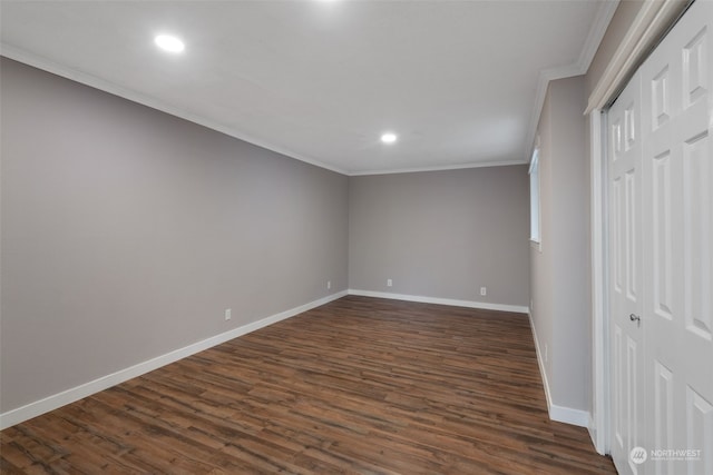 unfurnished bedroom with dark wood-type flooring, ornamental molding, and a closet