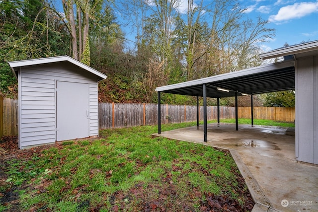 view of yard featuring a storage shed, a patio area, and a carport